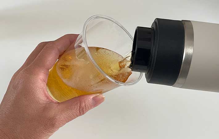 真空断熱炭酸ボトルからコップにビールを注ぐ手元