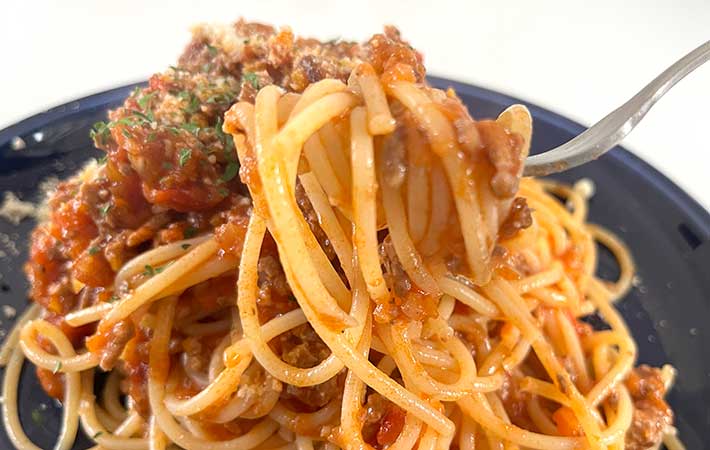 ミートソースパスタをフォークで持ち上げる様子