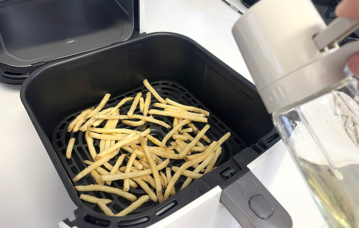 エアフライヤーのポテトにスプレーする様子