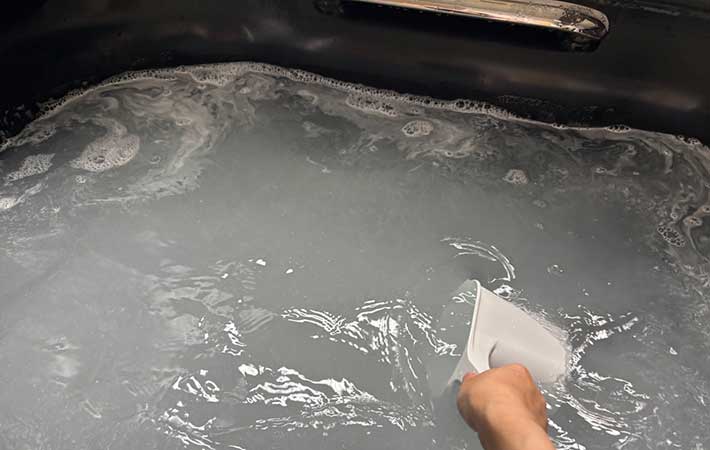 バスタブにオキシクリーンを入れてかき混ぜる様子