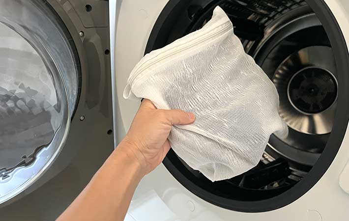 無印良品『高さを変えられる ランチバッグ ロールトップタイプ 大』を洗濯機へ入れる様子