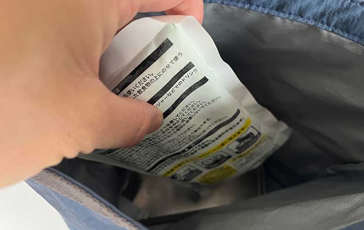 無印良品『高さを変えられる ランチバッグ ロールトップタイプ 大』に保冷剤を入れる手元