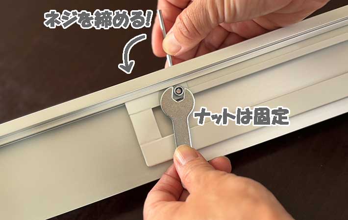 山崎実業『マグネット冷蔵庫横隠せるスライドフック』ナットを固定しネジを締める様子