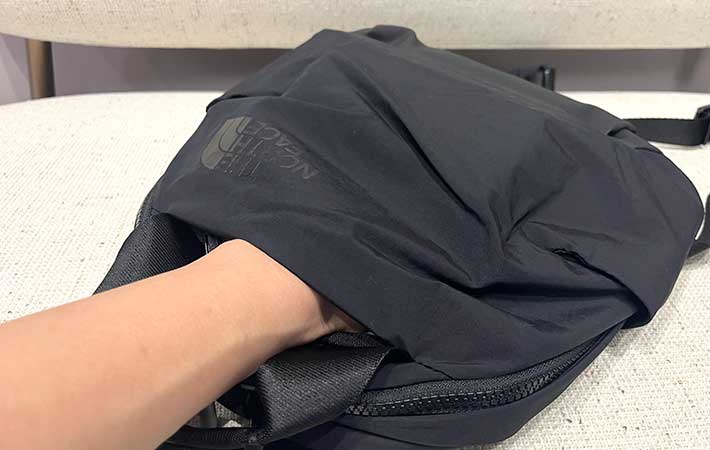 『ネバーストップミニバックパック』ファスナーつきポケットに手を入れる様子