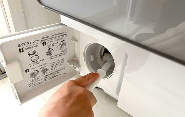 サンコー『びっくり洗濯機のホコリ取りま～す』を排水口に挿し込む