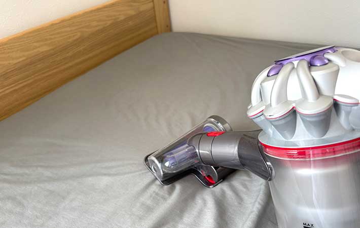 ベッドに掃除機をかける様子