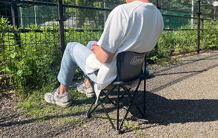 コンパクトな椅子に座る男性