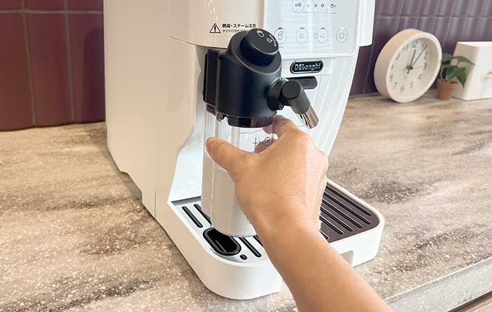 ミルクコンテナをスチーム管に取りつける様子